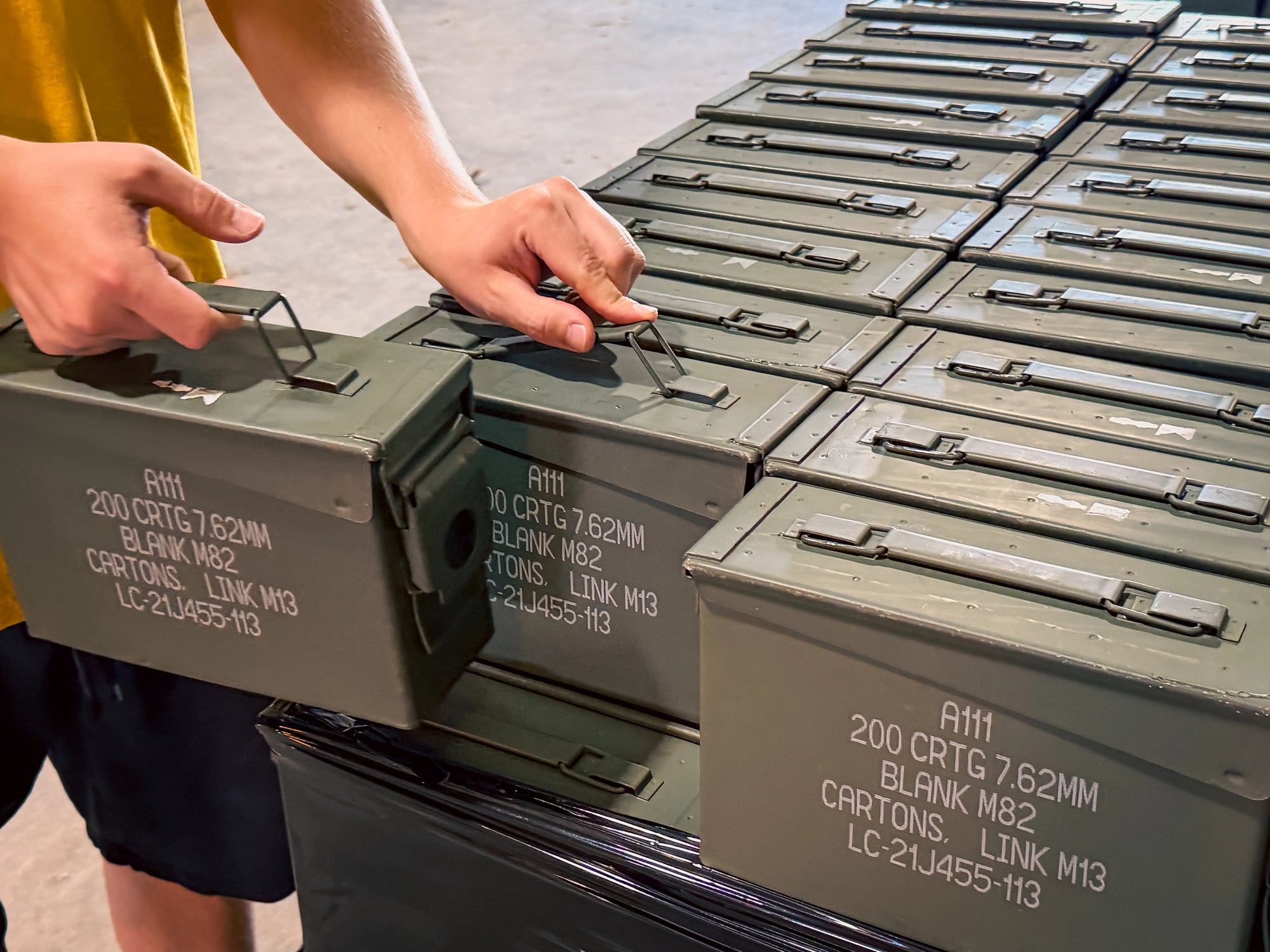 Person palletizing a wholesale order of surplus ammo cans